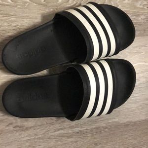 Black with white stripes Adidas slides.